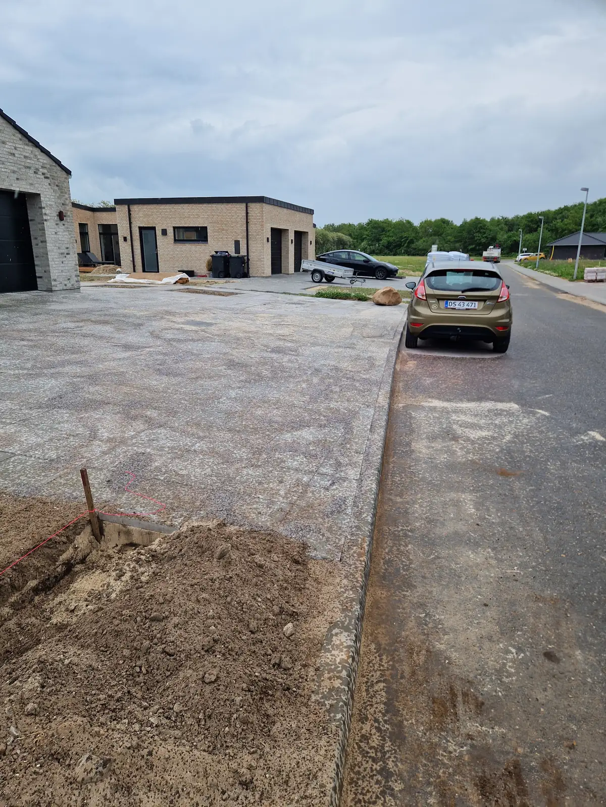Minigraver graver ud foran dobbeltgarage